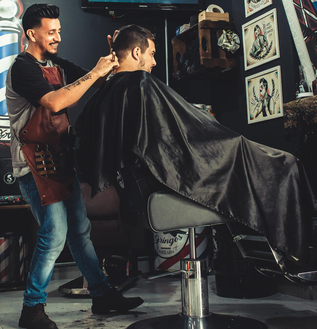 BARBER CUTTING MALE CLIENT'S HAIR